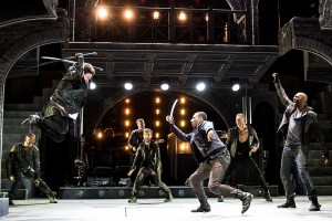 (foreground with swords, from left) Jeremy Woodard as Tybalt and Brandon Gill as Benvolio with the cast of THE LAST GOODBYE at The Old Globe.