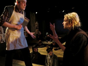 Zachary Baker-Salmon and Katherine Keberlein (with ensemble in the background) in Oracle's THE MOTHER. Photo by Ben Fuchsen.
