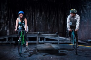 Aurora Adachi-Winter as Ora and Ricky Staffieri as  Eddie ride along the streets of Chicago in Buzz22 Chicago's Professional World Premiere of  Ghost Bike by Laura Jacqmin, directed by Company Member Sara Sawicki.