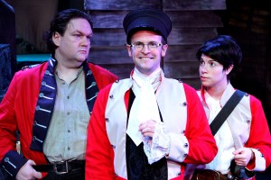 Sgt. Jackrum (Christopher M. Walsh, left) and Polly Perks (Sarah Price, right) deal with their inexperienced officer, Lt. Blouse (Robert Kauzlaric, center) in Lifeline Theatre’s world premiere production of “Monstrous Regiment,” adapted by Chris Hainsworth, directed by Kevin Theis, based on the novel by Terry Pratchett.