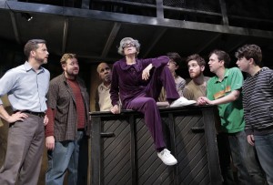 Caron Buinis (center) with (back, left to right), Eric Lindahl, Scott Danielson, Randy Johnson, George Toles, Garrett Lutz, Greg Foster and Seth Steinberg in Kokandy’s Productions’ THE FULL MONTY with music and lyrics by David Yazbek, book by Terrence McNally, directed by John D. Glover, choreography by Danny Spagnuolo and music direction by Kory Danielson. Credit: Joshua Albanese Photography.