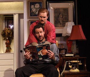 Stephen (Joe McCauley) and Mendy (JP Pierson) kill time with a magazine in Eclipse Theatre's THE LISBON TRAVIATA. Photo by Scott Dray.
