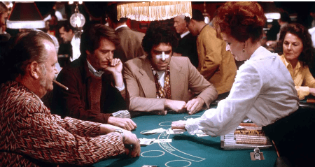 People playing poker around a casino table.