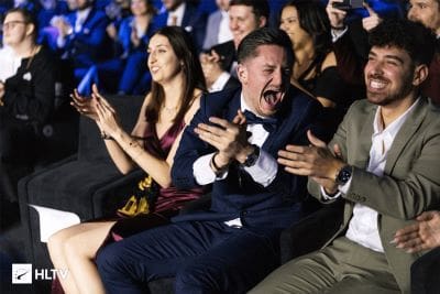 Excited audience members applauding and cheering at an event.