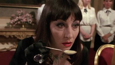 Woman with dark hair tasting food from a spoon.