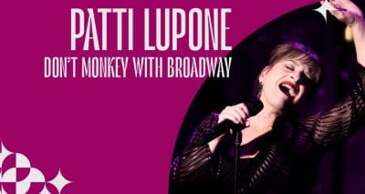 Batti Lupone performing energetically with a microphone on stage.