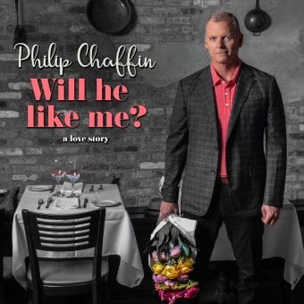 Man in suit holding flowers in a restaurant setting.
