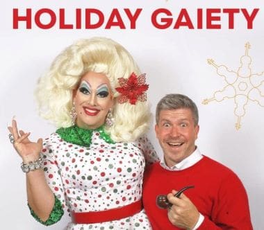 Festive holiday photo with a cheerful drag queen and a smiling man in Christmas attire.
