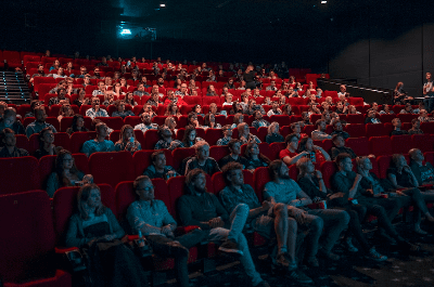 Audience watching a movie in a packed theater.