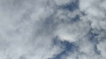 A sky filled with scattered gray clouds and patches of blue.