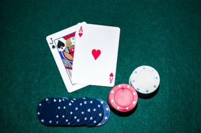 Playing cards with poker chips on a green felt table.