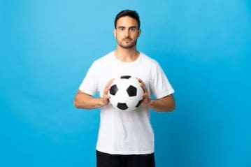 Man in white shirt holding a soccer ball against blue background.