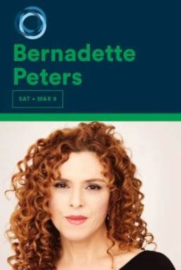 Portrait of a woman with curly red hair against a green background.
