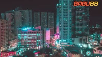 Cityscape at night with illuminated buildings and neon lights.
