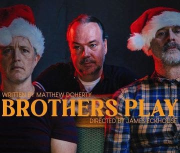 Three men in festive hats with serious expressions against a dark background.