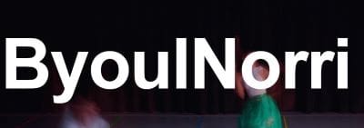 A person speaking on stage in front of a backdrop with large partial text 'oulNo'.