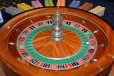 Close-up of a roulette wheel with numbered slots and a spinning ball.