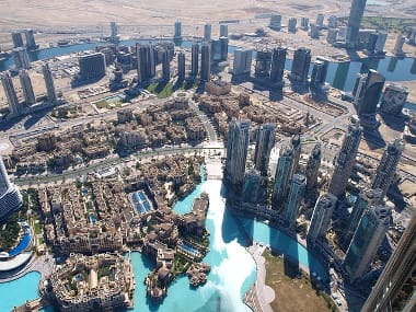 Aerial view of Dubai's Burj Khalifa and surrounding skyscrapers with a large pool.