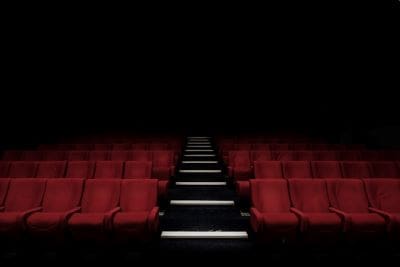 Empty movie theater with red seats and a dark ambiance.
