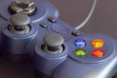 Close-up of a gray video game controller with colorful buttons.