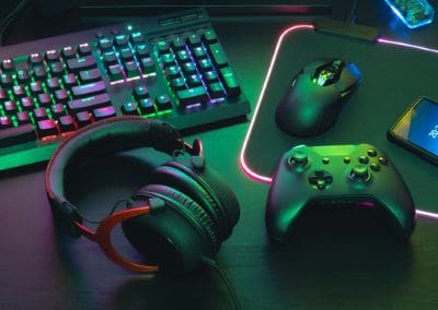 Gaming setup with colorful keyboard, mouse, headset, and controller.