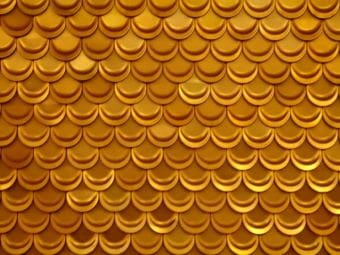 Close-up of shiny golden scallop-patterned texture.