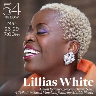 Portrait of Lillias White smiling joyfully with short blonde hair and elegant earrings.