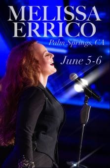 A woman singing passionately on stage with a microphone.