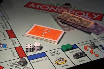 Monopoly game with dice, money, and property cards on the board.