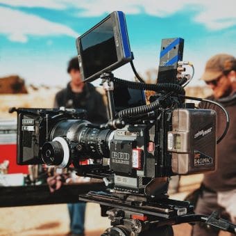 Professional camera setup on a film set with crew in the background.