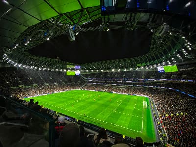 A brightly lit stadium hosting a soccer match with a large crowd.