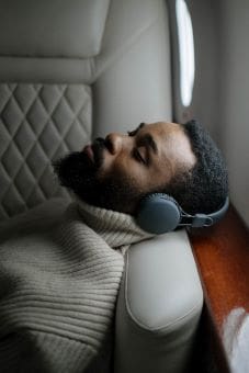 Man relaxing with headphones in a cozy sweater.