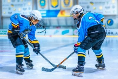 Two ice hockey players competing intensely on the rink.