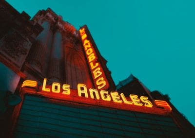 Neon lights glowing on the Los Angeles theater marquee at dusk.