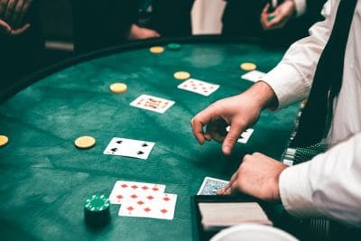 Players engaged in a lively poker game with cards and chips on the table.