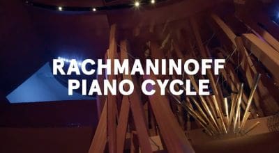 Signs displaying 'RAACHMANINOFF PIANO CYCLE' in a dimly lit setting.