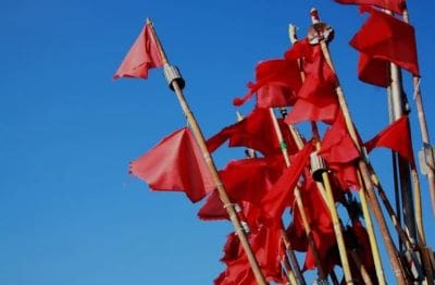 Red flags fluttering against a clear blue sky.