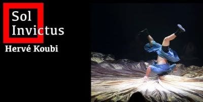 A dancer performing on stage with dynamic lighting and shadows.