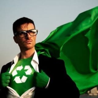Man with recycling symbol on chest and green cape, symbolizing eco hero.
