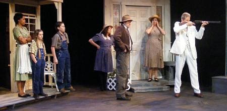 Actors performing a dramatic scene on stage in period costumes.