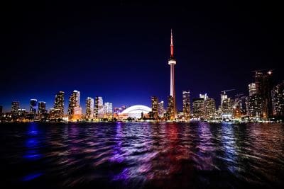 Toronto skyline at night with CN Tower illuminated.