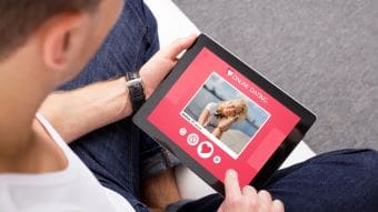 Person holding a red photo album with a picture of a woman on the cover.