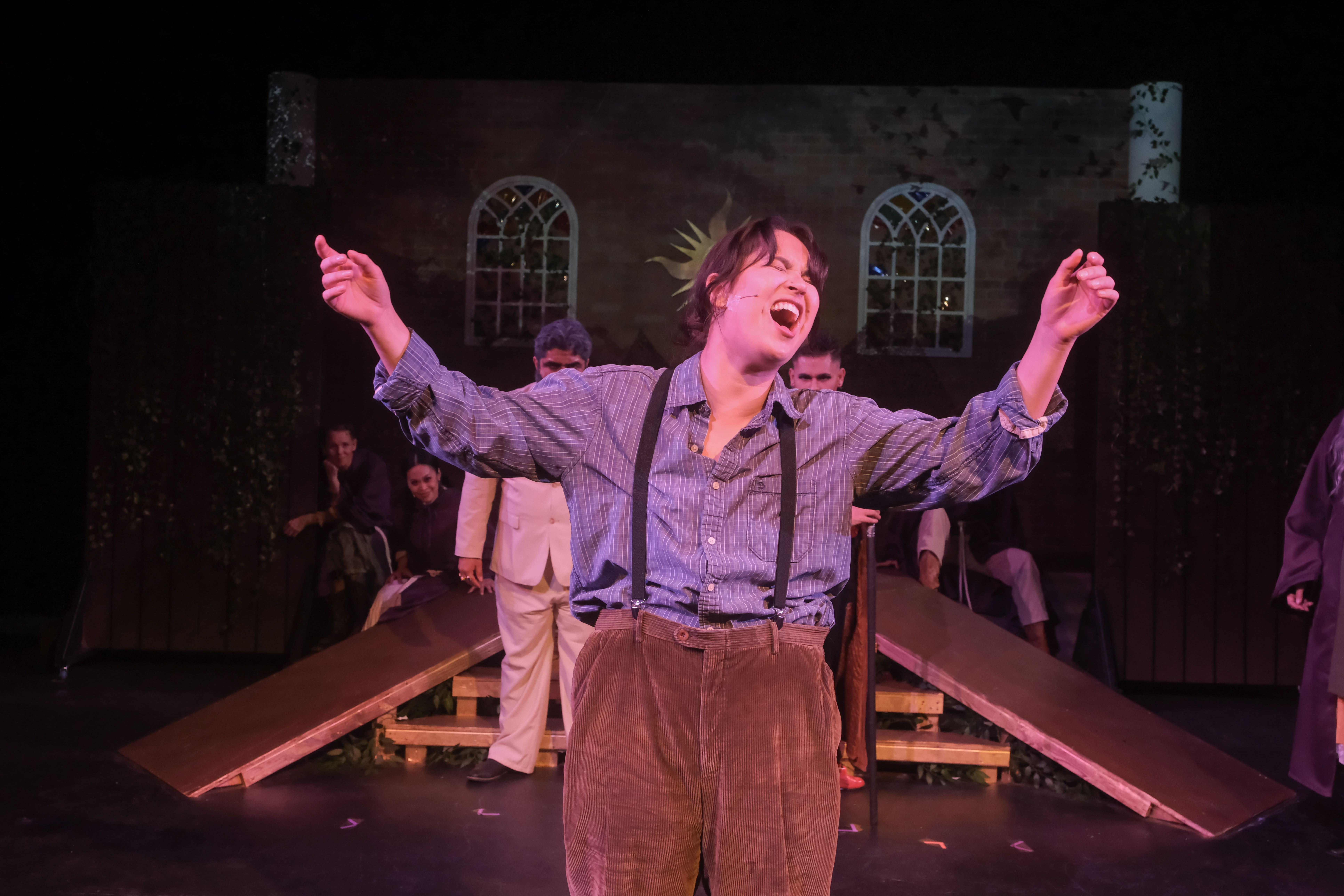 Actor passionately performing on stage in vintage attire.