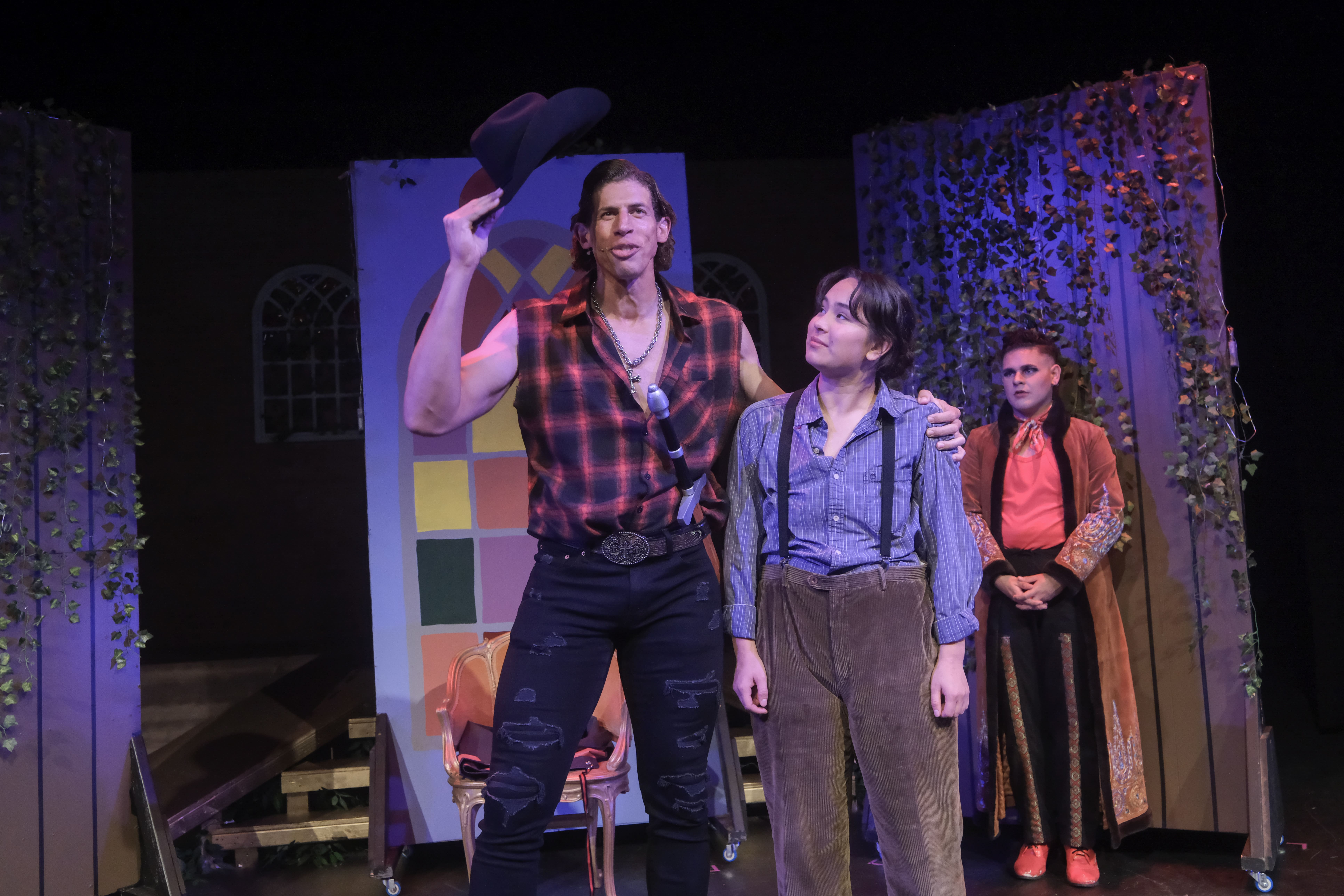Actors performing on stage in a dramatic scene at night.