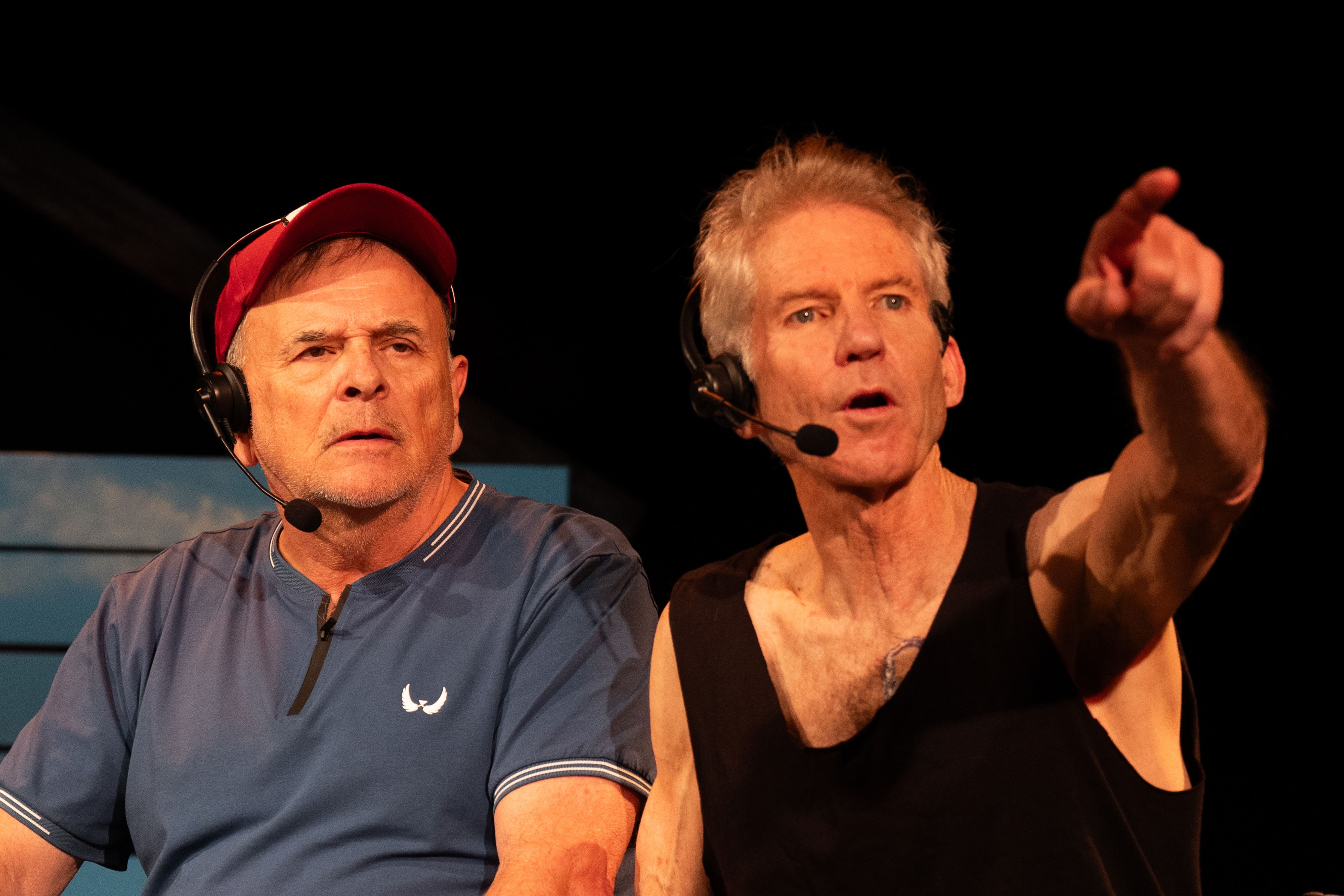 Two men performing on stage with microphones.