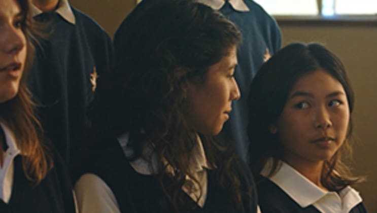 Profile of a young woman with dark hair in a school uniform.