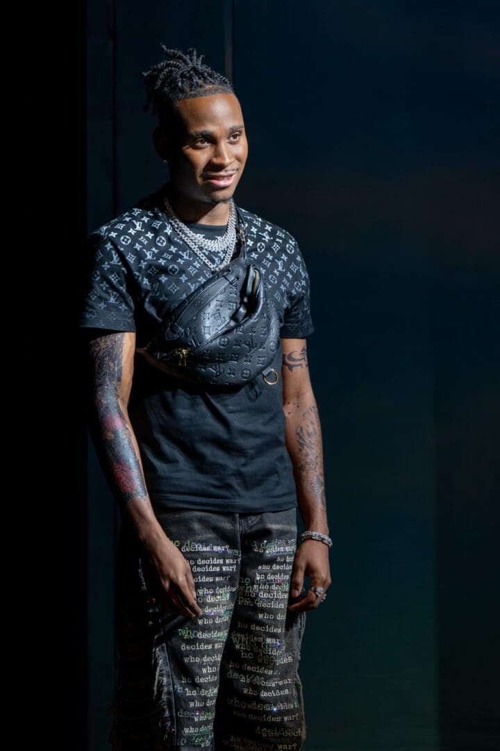 Model showcasing a stylish streetwear outfit with tattoos on arms.