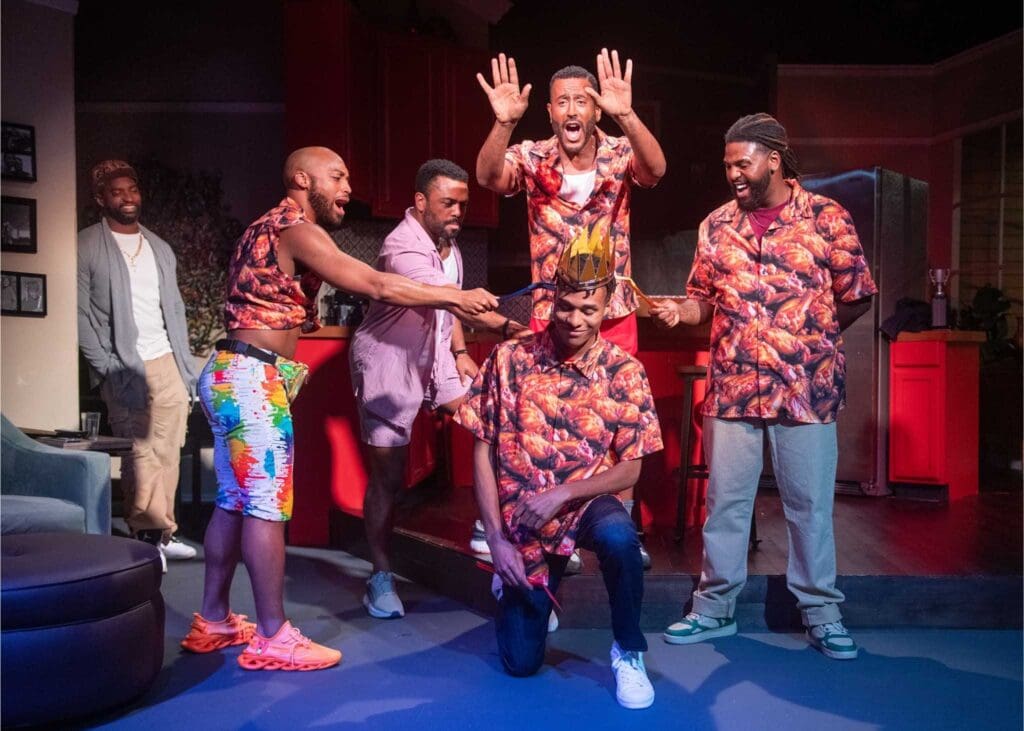 A group of men in colorful shirts celebrating on stage.