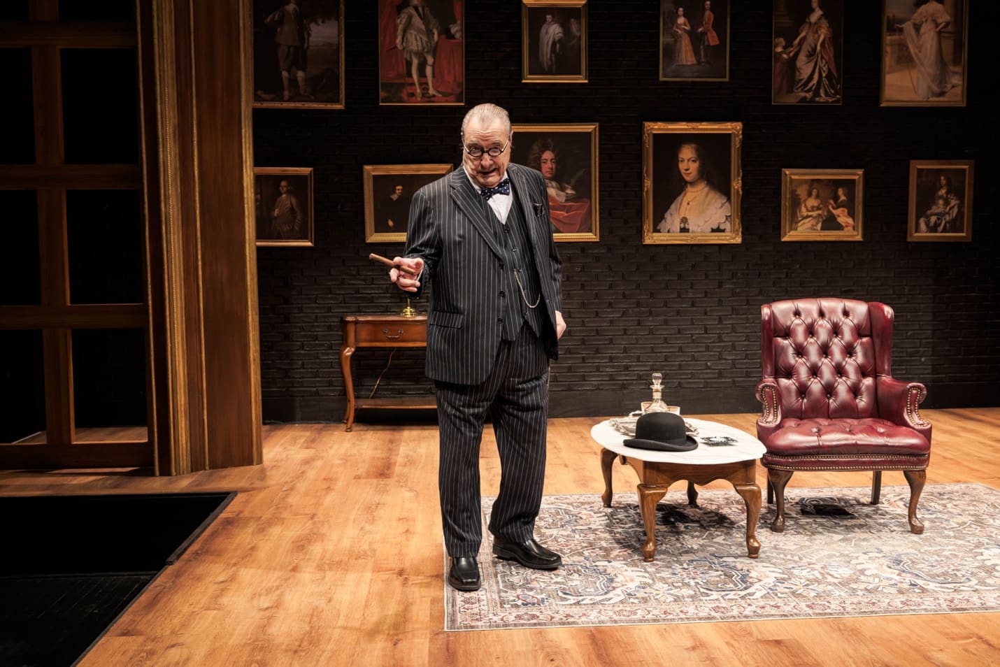 A man in a suit standing on a stage with vintage decor.