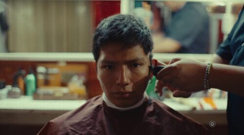 A man getting a haircut in a barbershop.